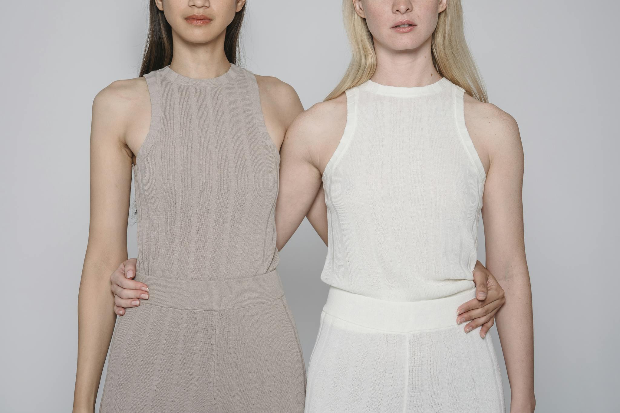 Stylish portrait of two women in neutral dresses showcasing minimalist fashion. Perfect for fashion and lifestyle themes.